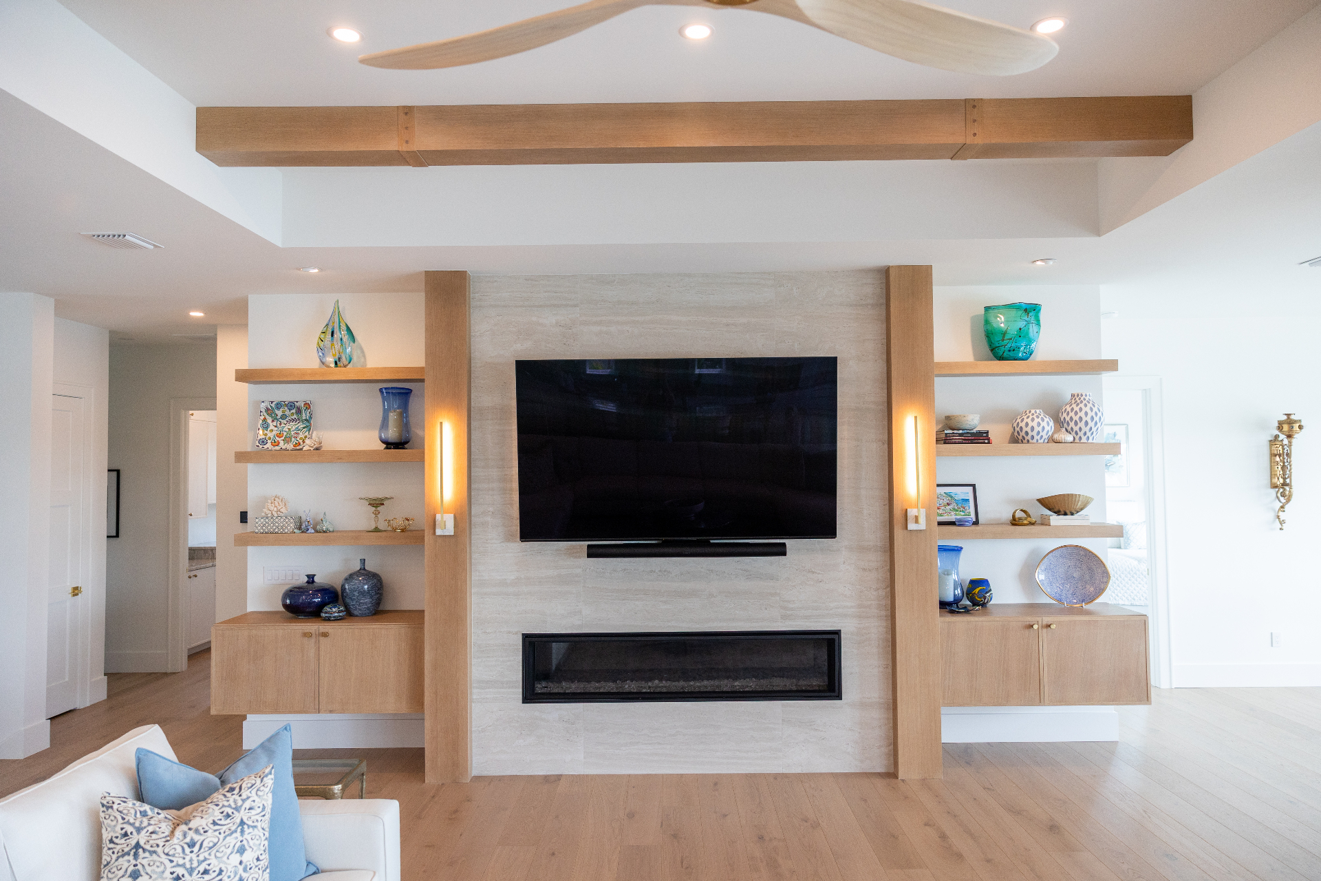 White oak entertainment wall with floating shelves and fireplace